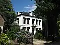 Villa in eclectische trant met neoclassicistische detaillering en bijbehorende erfafscheiding