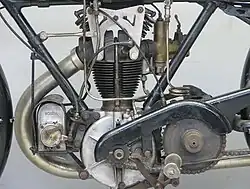 De linkerkant van het blok toont de Lucas-ontstekingsmagneet, de beugel die de cilinderkop vasthoudt en het lichte, open kettingscherm van de primaire aandrijving.