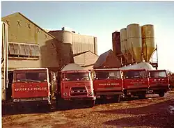 Het wagenpark begin jaren '80. Rechts de bulksilo's, midden de maalderij, links de oude Romney-loods.