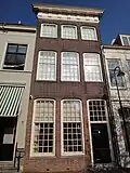 Pand met hoge lijstgevel met kroonlijst, waarin triglyphen en metopen en getoogde vensters met hardstenen dorpels