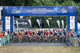 Start van het EK mountainbike 2019 beloften. Nordemann (in het oranje) rechts van het midden op de tweede rij met nummer 2.