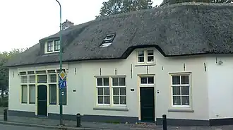 Broederschapshuisjes: gepleisterde lage met riet gedekte woning behorend bij serie lage huisjes uit de Dorpsstraat 1/5