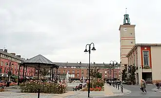 Vernieuwde markt (na de luchtbombardementen van 1940) met gemeentehuis en kiosk