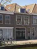 Bedrijfspand met bovenwoning, in opzet mogelijk 18de-eeuws. Pui gewijzigd in 19de eeuw en in 1984.