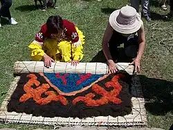 Voorbereiding voor het vilten van in patroon gedrapeerde wol om een Ala-kiyiz tapijt op traditionele manier te vervaardigen in Kyrgyzstan