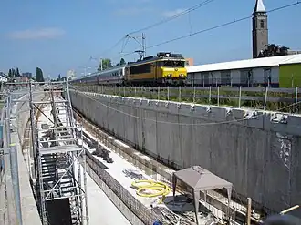 De verdiepte spoorbak in aanleg. Rechtsboven rijdt de Intercity Berlijn over het noodspoor.