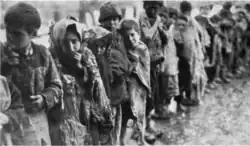 Oorspronkelijk onderschrift: "Kinderen wachten in de sneeuw voor toegang tot de 'Weesstad', een dagelijks spektakel van 's morgens vroeg tot 's avonds laat" (The Story of Near East Relief, 1930).