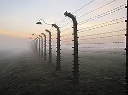 Hekwerk met prikkeldraad bij concentratiekamp Auschwitz, in de mist