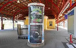 Stationsgebouw en perron onder de stalen overkapping.