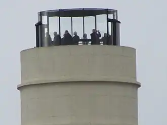 De glazen lift die bezoekers net boven een van de schoorstenen brengt.