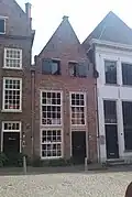 Huis met gepleisterde tuitgevel, moderne werkplaatsdeur