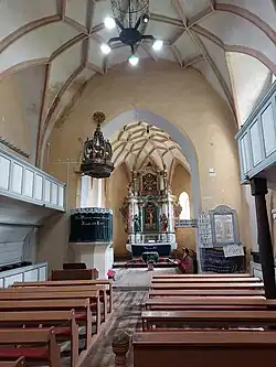 Interieur van de kerk gezien naar het koor toe met links de preekstoel