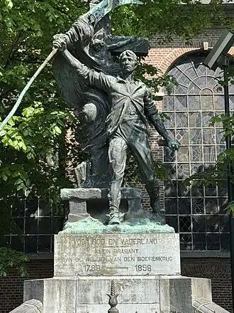 Standbeeld van een boerenkrijger met opgeheven zeis, symbool van het verzet tijdens de Boerenkrijg van 1798, in Bornem.