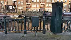 De naamplaat op de leuning die ver tot op de kade doorloopt (maart 2019)