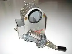 Caran d'Ache-puntenslijper, gedemonteerd. Er is geen zonnewiel en maar één planeetwiel. De planeetwieldrager wordt aangedreven door een slinger en het planeetwiel gaat schuil achter de slijprol.