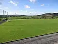 Het tweede veld van Corofin GAA, met de Fergus zichtbaar op de achtergrond Bij de tweede lichtmast van links.