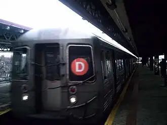 Een trein van lijn D verlaat station 62nd Street.