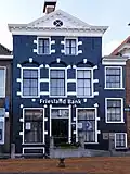 Woonhuis met verdieping en zolderverdieping onder zadeldak en onderkelderde vleugel onder dwarsdak (Friesland Bank)