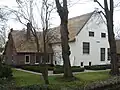 Boerderij met steen: "dit huis is van outs genaamd de Hoogkamer 1651". Topgevel met dwars op het woonhuis vleugel met topgevel, zomerhuis. Langhuistype