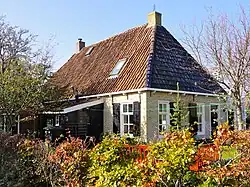 De Oere 10, pand zonder verdieping onder schilddak met achter rode en voor blauw verglaasde golfjespannen