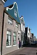 Huis met bakstenen straatgevel, waarboven een houten klokgevel