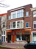 Pand met winkelruimte en bovenwoningen, in 1927 gebouwd naar ontwerp van L.C. Kalis, in een expressionistische bouwstijl die gekenschetst kan worden als een kubistische variant op de Amsterdamse School.