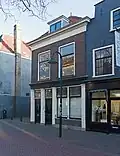 Woonhuis met beneden- en bovenwoning, midden-19de-eeuws van karakter, in sobere traditioneel-classicistische vormen.