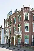 Pand met beneden- en bovenwoning, samen met Koningsplein 101/103 en 109/111 in blokje van drie, in 1911 gebouwd in een stijl met invloeden van de nieuwe kunst, ontworpen door architect J.M. van den Berg.
