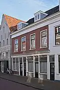 Woonhuis met beneden en bovenwoning in traditioneel-classicistische vormen, wellicht in de vroege 19de eeuw ontstaan als onderdeel van het rijtje Molenstraat 3/5 tot 11/11a.