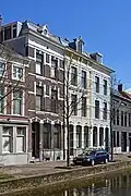 Woonhuis in blokje van drie woningen met een voorgevel in rijke eclectische bouwtrant, in 1884 gebouwd door aannemer G. de Ronde. Het blokje is symmetrisch opgezet met een accent op het middelste pand waarvan de gevel als risaliet naar voren springt en iets rijker is behandeld. Het pand is van belang als onderdeel van het blokje Oude Delft 12/12a/12b.
