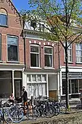 Winkelwoonhuis, in oorsprong waarschijnlijk uit de 17de eeuw, maar ingrijpend gewijzigd in het laatste kwart van de negentiende eeuw. Voorgevel in eclectische stijl met elementen uit de renaissance en het classicisme.