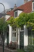Pand in rijtje van vier, in opzet identieke, traditioneel vormgegeven woningen uit de 19e eeuw, Pluympot 4t/m 10.