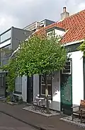 Pand in rijtje van vier, in opzet identieke, traditioneel vormgegeven woningen uit de 19e eeuw, Pluympot 4t/m 10.