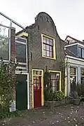 Woonhuis met klokgevel, mogelijk uit de 18e eeuw. Pand in oorsprong misschien ouder maar van na de kruithuisontploffing van 1654.