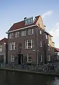 Blokje met beneden- en bovenwoningen, van het type portiekwoning, gebouwd naar een ontwerp van H.W. Elfferich uit 1938.