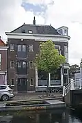 Pakhuis, in de tweede helft van de 19e eeuw gebouwd in een traditionalistisch-classicistische bouwtrant, in oorsprong behorend bij het rechts belendende winkelwoonhuis Verwersdijk 116.