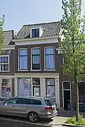 Van oorsprong winkelwoonhuis, in opdracht van H.G. Wijnman in 1895 gebouwd volgens een ontwerp van C.J.L. Kersbergen uit 1894, in een traditionalistisch-classicistische bouwstijl. Het is van belang als goed en gaaf bewaard gebleven winkelwoonhuis in een traditionalistisch-classicistische stijl uit het einde der 19e eeuw. Het is van belang als werk in het oeuvre van de Delftse architect C.J.L. Kersbergen.