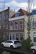 Pand met beneden- en bovenwoning, uit de tweede helft van de 19e eeuw, in een sobere traditionalistisch-classicistische bouwtrant.