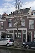 Bedrijfspand met bovenwoning uit het eerste kwart van de 20e eeuw, in een traditionalistische bouwtrant.