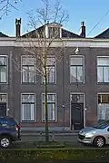 Woonhuis, onderdeel van rijtje van drie identieke huizen, in het laatste kwart van de 19de eeuw, gebouwd in traditioneel classicistische vormen, ter plaatse van de uit 1836 daterende en in 1886 afgebroken St. Hippolytuskerk.