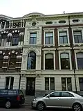 Linkerhelft van dubbel herenhuis in eclectische bouwstijl, met voornamelijk aan de renaissance, de Lodewijk XIV- en de Lodewijk XVI-stijl en het Empire ontleende motieven