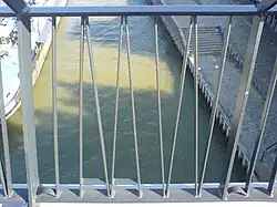 Detail van de Snelbinder, met het woord "WAAL" in spiegelbeeld gevormd door de spijlen in het hek