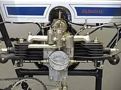 Hoewel het blok van het Model C al lager hing dan de oorspronkelijke versie, was er nog steeds een uitsparing in de tank nodig om ruimte te maken voor de ontsteking. Aan de onderkant zitten twee stoterstangen voor de beide zijkleppen. De kopkleppen waren nog snuffelklepen.