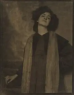 Vrouw met donkere kleren en lichte sjaal