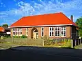 R.K. SCHOOLGEBOUW, gebouwd in 1922 in opdracht van de R.K. gemeente. In eerste instantie was het een gemengde school, later werd er achter deze school een meisjesschool gebouwd en deed deze school dienst als jongensschool.