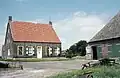 Boerderij, bestaande uit grote schuur- en stal onder een rieten wolfdak, met planken wanden en afzonderlijk woonhuis