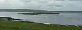 Eynhallow vanaf Roussay, met op de achtergrond Mainland Orkney.