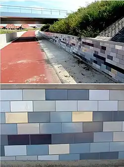 Op de betonnen randen van de fietstegel zijn tegeltableaus aangebracht. Voor de kleurstellingen liet de kunstenaar zich inspireren door de weerspiegeling van het nabij  gelegen water van het Alddjip. De tegels zijn gemaakt door Tichelaar, Makkum.