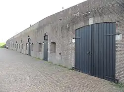 Bakstenen bomvrije kazerne met geheel rechts de grote deuren van de kanonremise