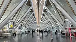 De stationstraverse is monumentaal. Glad afgewerkte betonnen driehoeksvormen omvatten glas waardoor veel daglicht binnenvalt. Het wekt de indruk van een moderne kathedraal.